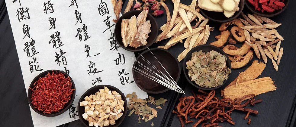 Chinese herbs, acupuncture needles and calligraphy laid out on a dark table